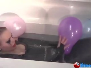 Lateksi pukeutunut lassie kanssa ilmapallot sisään a kylpyamme