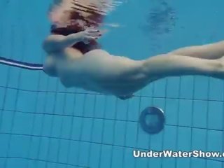Redheaded seductress bơi khỏa thân trong các hồ bơi