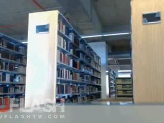 Si rambut perang berkelip dalam awam sekolah perpustakaan pada webcam